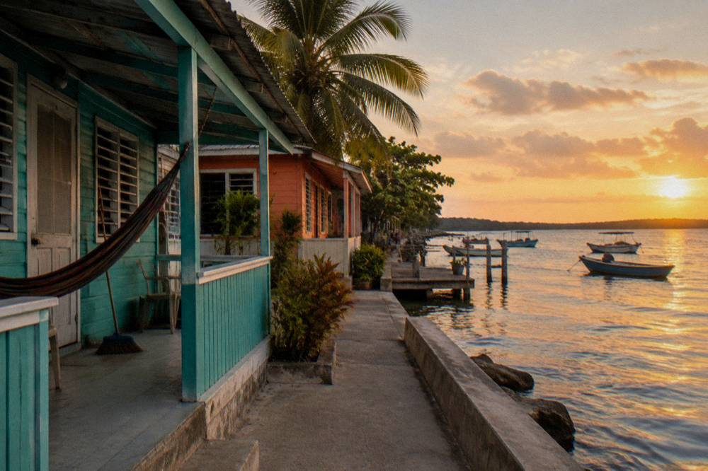 Colorful fishing village waterfront with boats and a pier in warm evening light